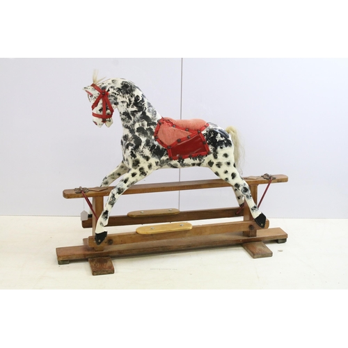 567 - Early / mid 20th century carved wooden dappled painted rocking horse with red saddle and reins, 79cm... 