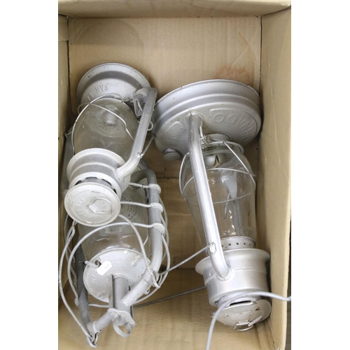 413 - Variety of oil lamp optics and white shades, together with an assortment of storm lanterns