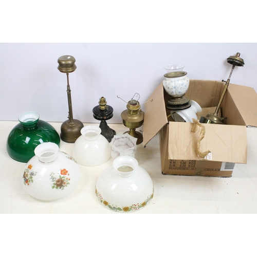 439 - Selection of antique oil lamps and glass shades in varying shapes and sizes, with hand painted examp... 