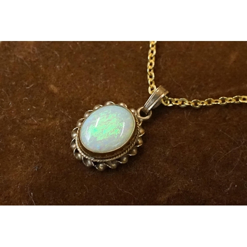 199 - A 9ct gold white opal pendant on 9ct gold chain link necklace within display case.