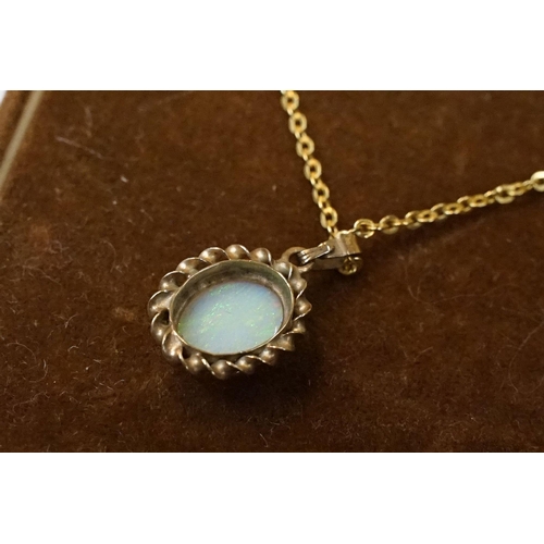 199 - A 9ct gold white opal pendant on 9ct gold chain link necklace within display case.