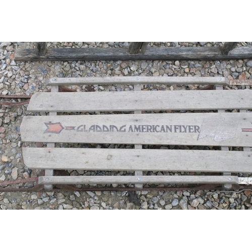 541 - Pair of vintage slatted wood sledges / sleighs including one American flyer example.