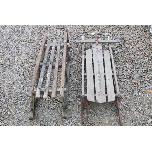 541 - Pair of vintage slatted wood sledges / sleighs including one American flyer example.