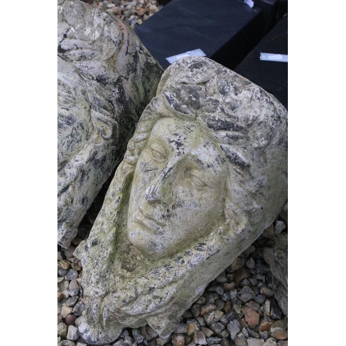 542 - Pair of cast concrete wall pocket planters in the form of classical masks. Measures 43cm tall.