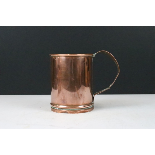 135 - Set of three copper graduating measuring tankards with loop handles, largest 14cm high