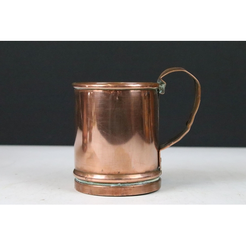 135 - Set of three copper graduating measuring tankards with loop handles, largest 14cm high