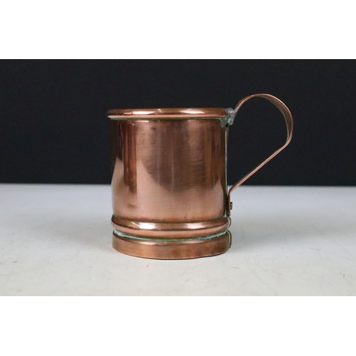 135 - Set of three copper graduating measuring tankards with loop handles, largest 14cm high