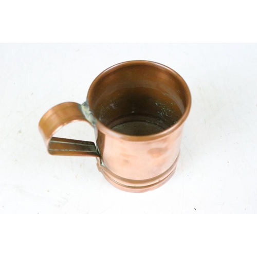 135 - Set of three copper graduating measuring tankards with loop handles, largest 14cm high