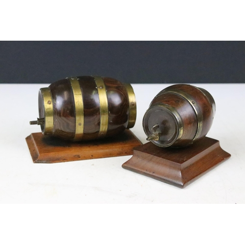 136 - Two lignum vitae string barrels, table top cask coopers barrels with brass detail both on mounted wo... 