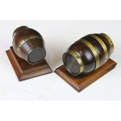 136 - Two lignum vitae string barrels, table top cask coopers barrels with brass detail both on mounted wo... 