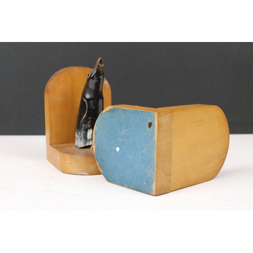 143 - Pair of Art Deco wooden bookends, each mounted with a horn penguin, 15cm high