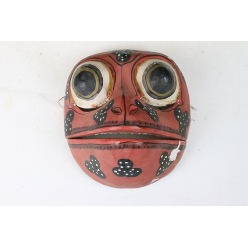 148 - Two mid 20th century folk art tribal wooden hand painted frog masks with articulated jaws, H 17cm