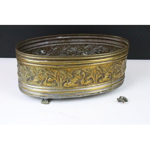 158 - Brass oval planter with relief swan surround decoration, raised on three brass paw feet (one paw pre... 