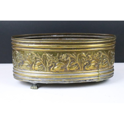 158 - Brass oval planter with relief swan surround decoration, raised on three brass paw feet (one paw pre... 