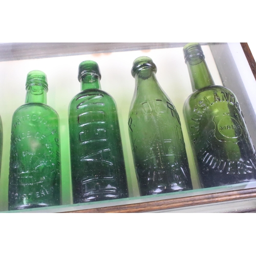 162 - Five 20th century green glass beer bottles in wood and glass display case H 36cm W 51cm D 11cm