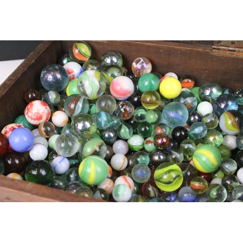 174 - Oak carved wooden box containing a large collection of glass marbles, box measures 15cm wide