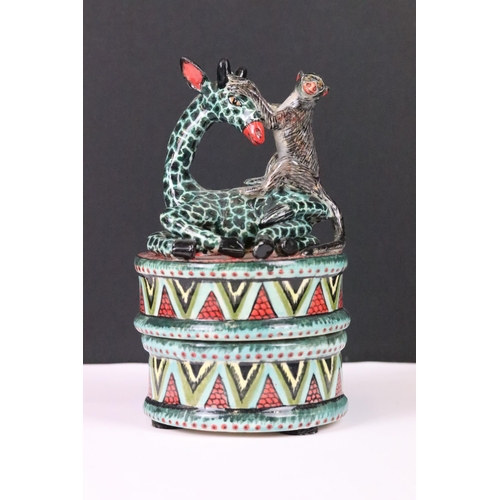 204 - George E Moshe pottery jar and cover, the lid moulded with a monkey sitting on a giraffe, painted ma... 