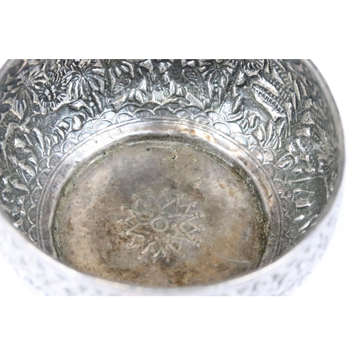 206 - A Indian silver / white metal bowl with repousse decoration featuring wild animals.