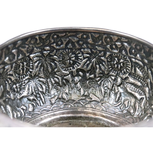 206 - A Indian silver / white metal bowl with repousse decoration featuring wild animals.