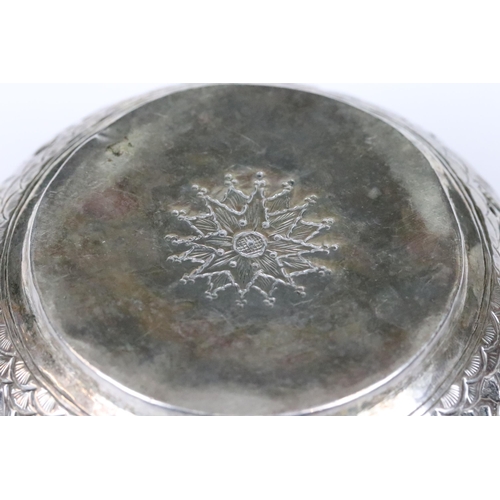 206 - A Indian silver / white metal bowl with repousse decoration featuring wild animals.