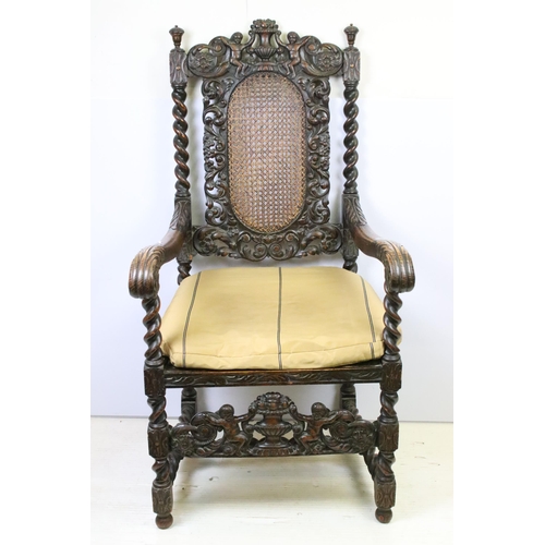 582 - Edwardian carved oak gothic revival open arm chair having carved and pierced back rest with caned ce... 