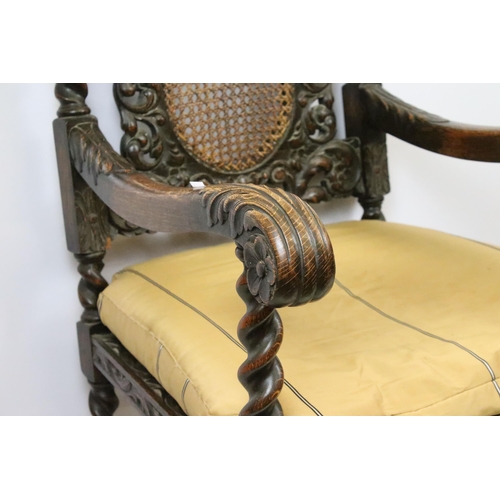 582 - Edwardian carved oak gothic revival open arm chair having carved and pierced back rest with caned ce... 