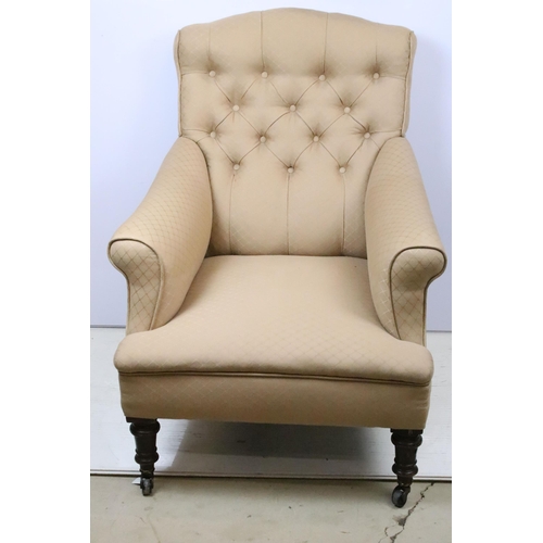 588 - Victorian framed arm chair with later upholstery raised on ceramic castors. the chair having a butto... 