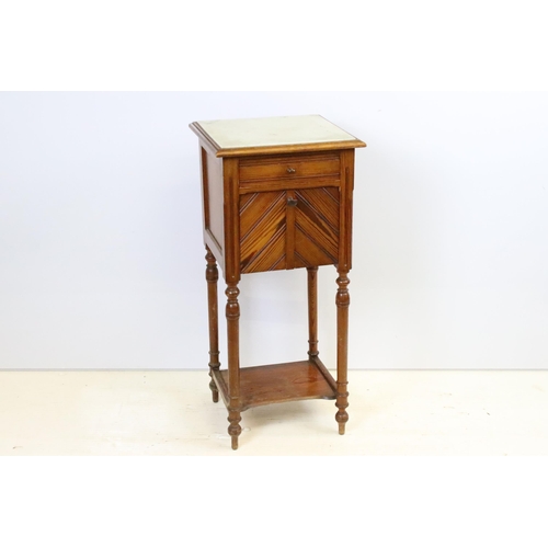 592 - Early 20th century pine bedside pot stand, the inset marble top above single drawer and fall front c... 