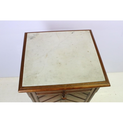 592 - Early 20th century pine bedside pot stand, the inset marble top above single drawer and fall front c... 