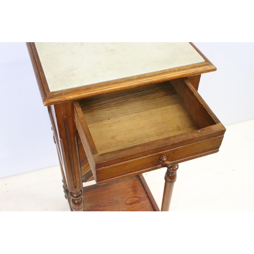 592 - Early 20th century pine bedside pot stand, the inset marble top above single drawer and fall front c... 