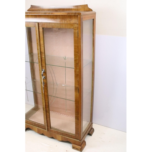 596 - Art Deco walnut veneered two door cabinet, with etched glass doors, with two glass shelves, with key... 