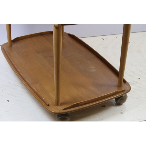 603 - Ercol elm three-tier hostess trolley, the top with two drop leaves, on casters, 76cm high x 95cm wid... 