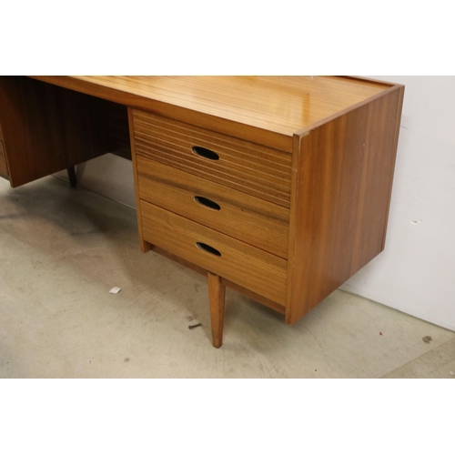 615 - Mid century teak dressing table, with swing mirror, above an arrangement of six drawers above taperi... 