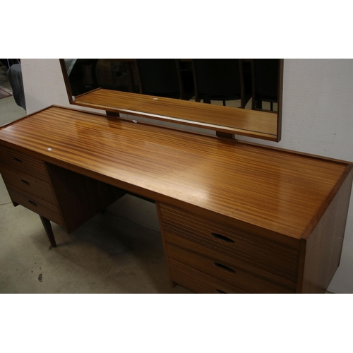 615 - Mid century teak dressing table, with swing mirror, above an arrangement of six drawers above taperi... 