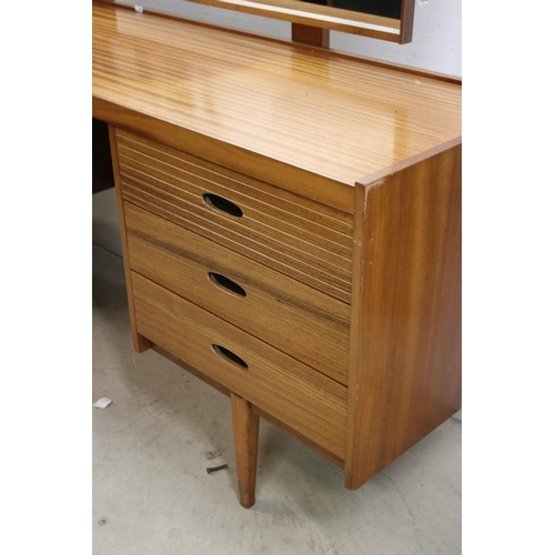 615 - Mid century teak dressing table, with swing mirror, above an arrangement of six drawers above taperi... 