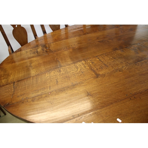 622 - Bylaw The Furniture Makers oval oak refectory table with ten chairs, the planked top, above substant... 