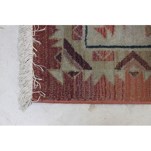 578 - Terracotta ground woollen rug with geometric central design and borders, 232 x 160cm