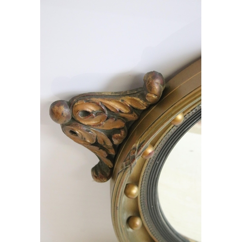 618 - Regency style gilt gesso convex wall mirror, of circular form, with eagle finial, 76cm high