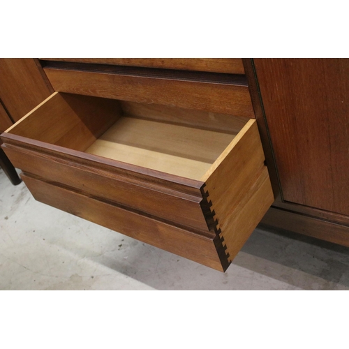 634 - Mid century teak sideboard with four drawers flanked by two pairs of cupboard doors, on square taper... 