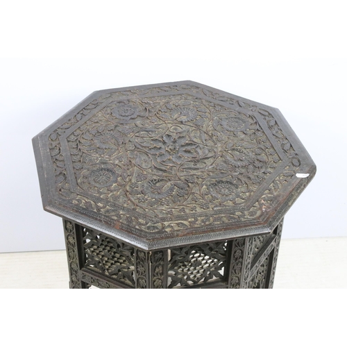 636 - Eastern carved hardwood folding octagonal occasional table, the top carved with flowers and foliage,... 