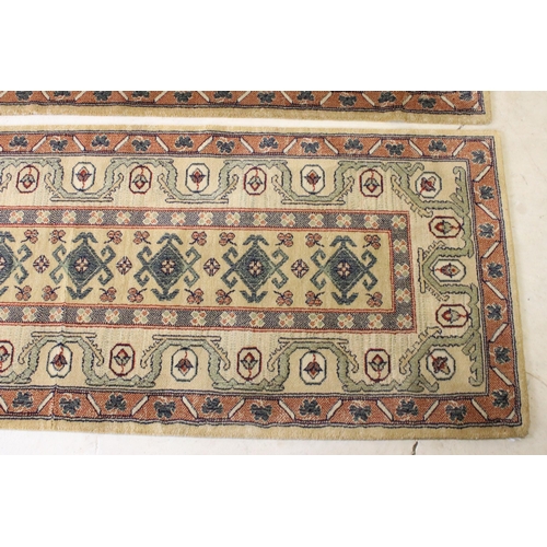 637 - Pair of 20th century cream ground wool work runners, with geometric design, each 253 x 70cm