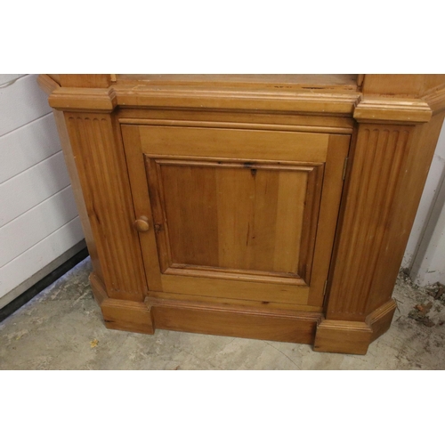 643 - 20th century pine corner cupboard, the upper section with two open shelves above single cupboard doo... 