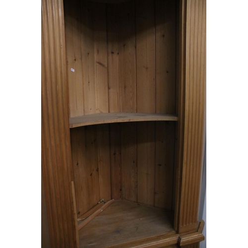 643 - 20th century pine corner cupboard, the upper section with two open shelves above single cupboard doo... 