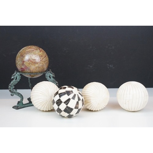 56 - Set of four decorative bone display balls together with a stone sphere on three dragon base stand