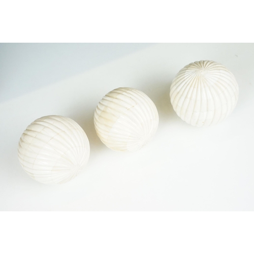 56 - Set of four decorative bone display balls together with a stone sphere on three dragon base stand