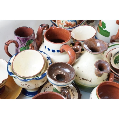 106 - Large assortment of Motto ware, Torquay and Devon ware, to include jugs, vases, plates, mugs, candle... 