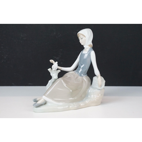 78 - Lladro figurines in the form of girl with rabbit and girl with dove together with Nao woman with mar... 