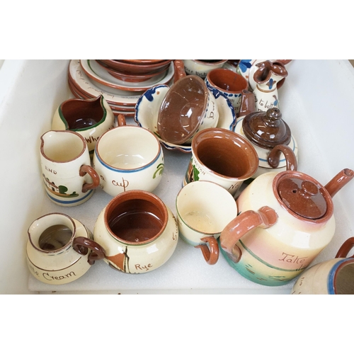 106 - Large assortment of Motto ware, Torquay and Devon ware, to include jugs, vases, plates, mugs, candle... 