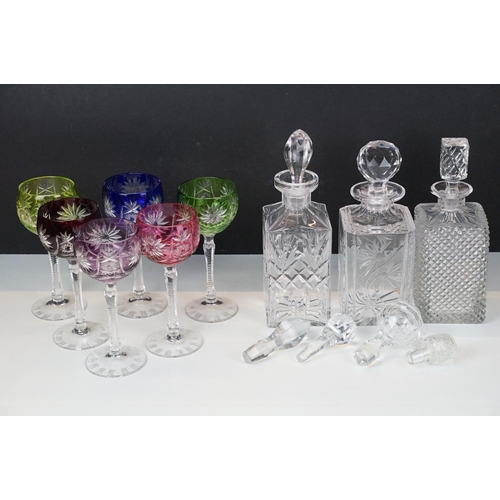 97 - Three glass decanters with etched and diamond cut examples together with an assortment of stoppers i... 