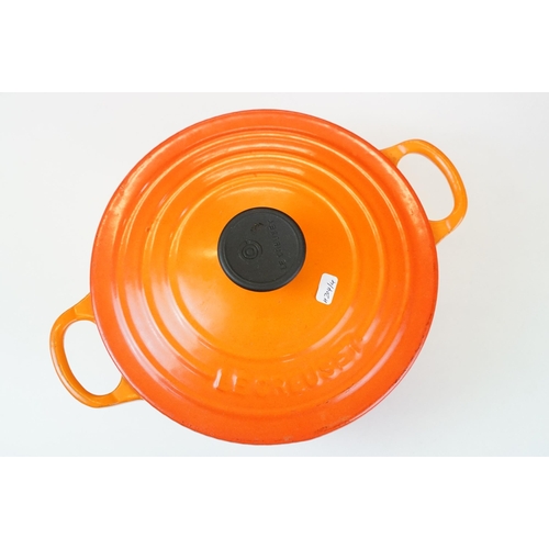 127 - Three Le Creuset lidded orange pans in graduating sizes, two round, 18 & 26 and one oval example BC,... 